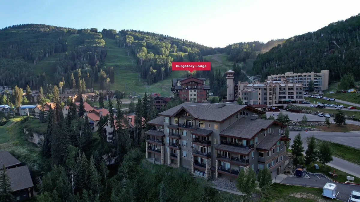 A wide exterior view of Purgatory Lodge framed by dramatic mountain vistas and a tranquil, natural setting. The image hints at multiple outdoor activities available year-round, from skiing to hiking and mountain biking, underscoring the lodge's versatility as a four-season adventure hub.